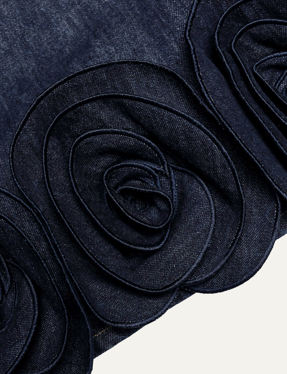 Dark blue denim mini dress with 3D rosette details along the hem details.
