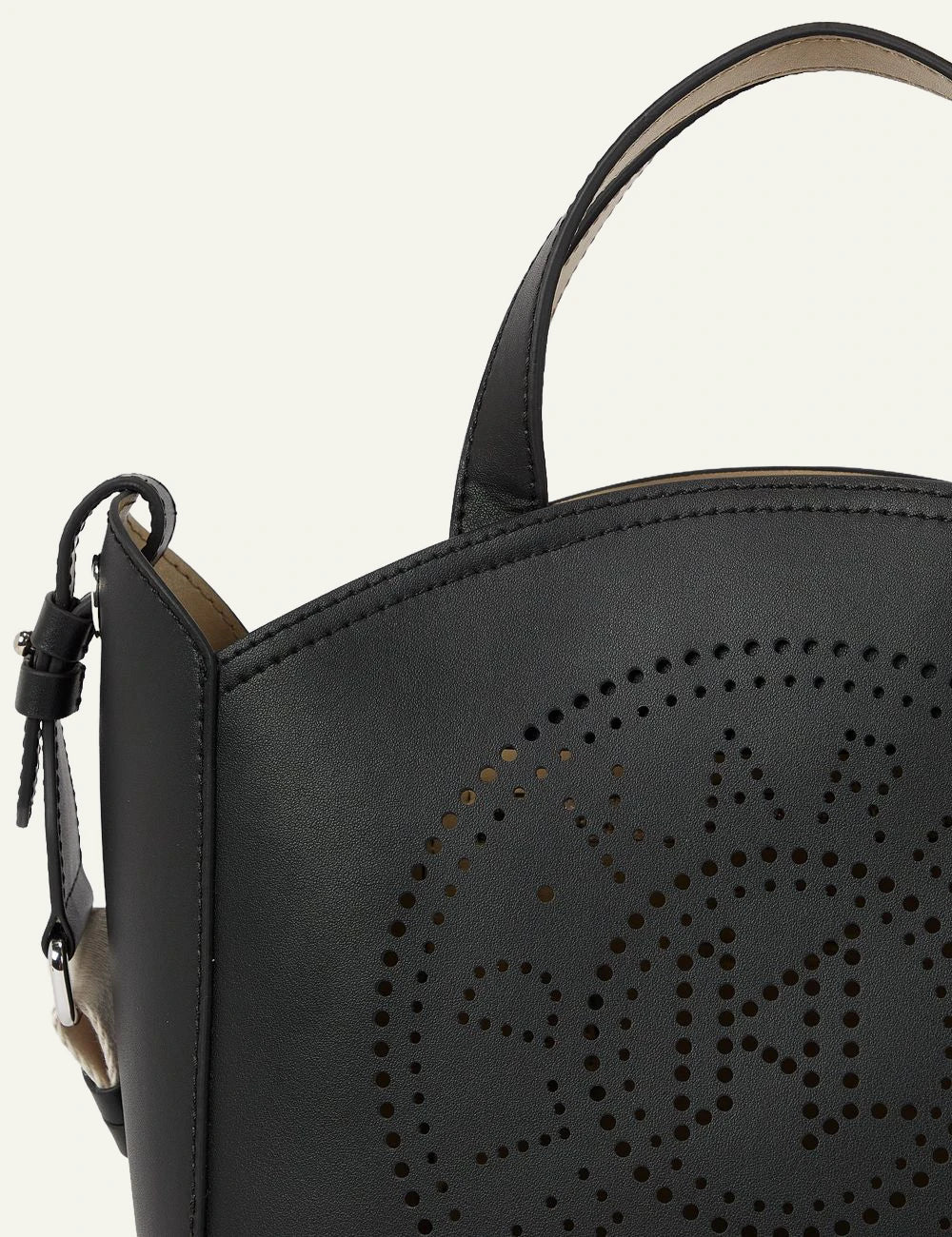 Detail close-up of Karl Lagerfeld perforated logo on black leather tote