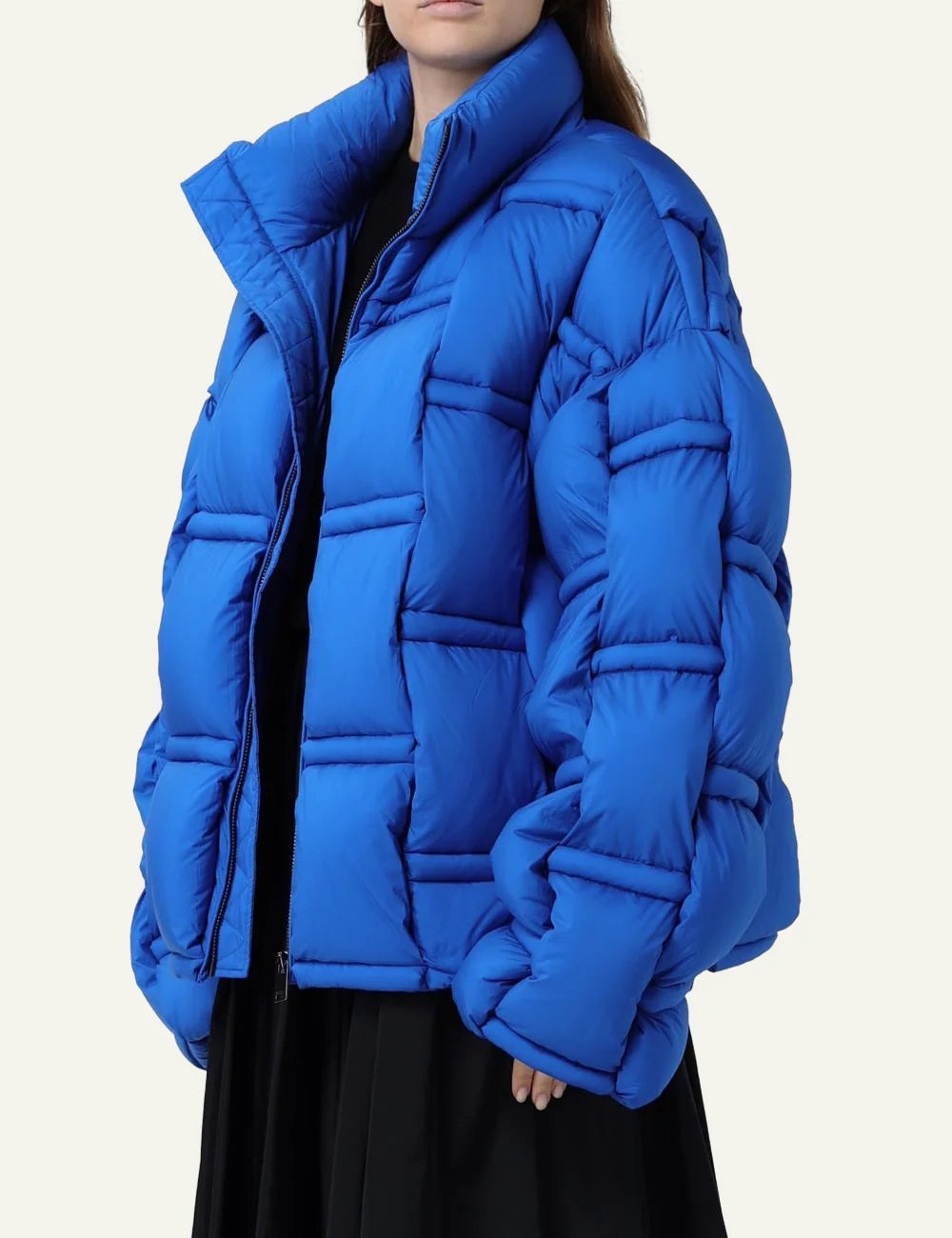 Side view of bold blue oversized puffer με structured quilting, modern statement women’s jacket.