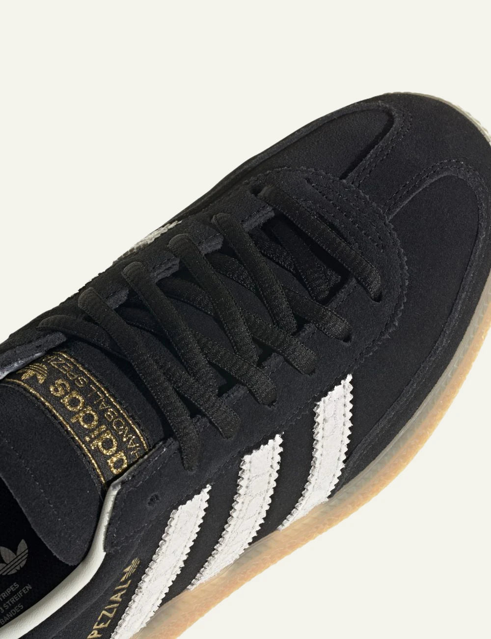 Adidas Handball Spezial black leather sneakers white stripes angled view