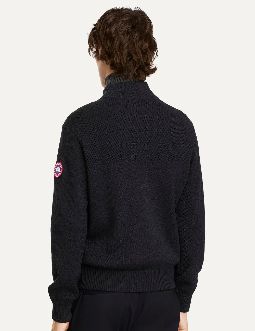 Canada Goose men's HyBridge Knit Jacket in black merino wool with down-filled quilted front, ribbed collar and cuffs, zip closure and logo patch back