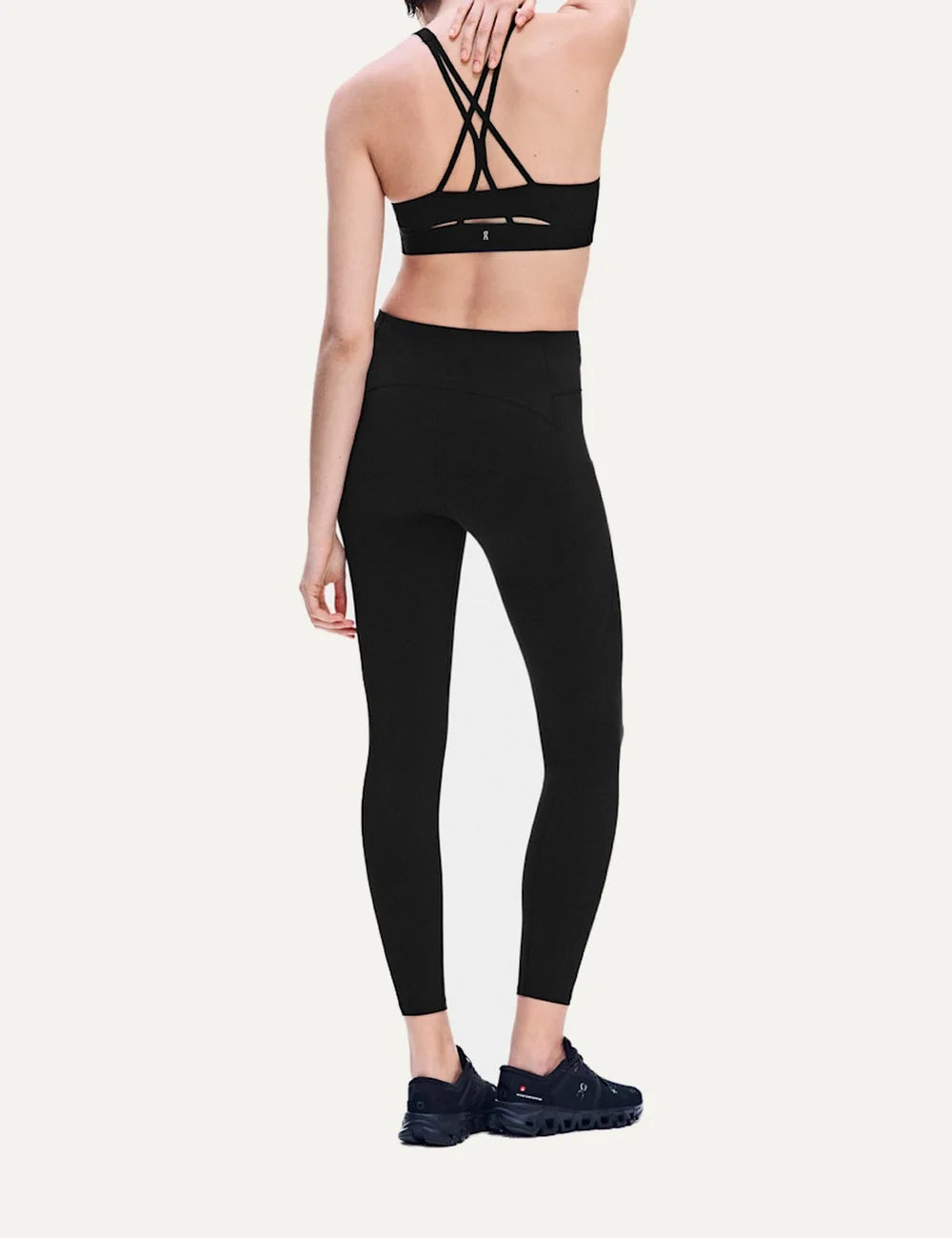 On women's black high-waisted athletic leggings with close fit, ankle length, soft SenseTec fabric, four-way stretch, seamless front and side phone pocket back