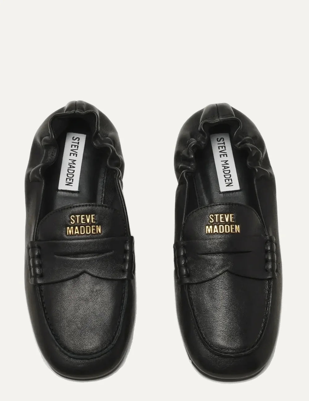 Steve Madden women's black leather loafers with gold-tone metal detail on penny strap, gathered heel, rounded toe and flat black rubber sole, top view