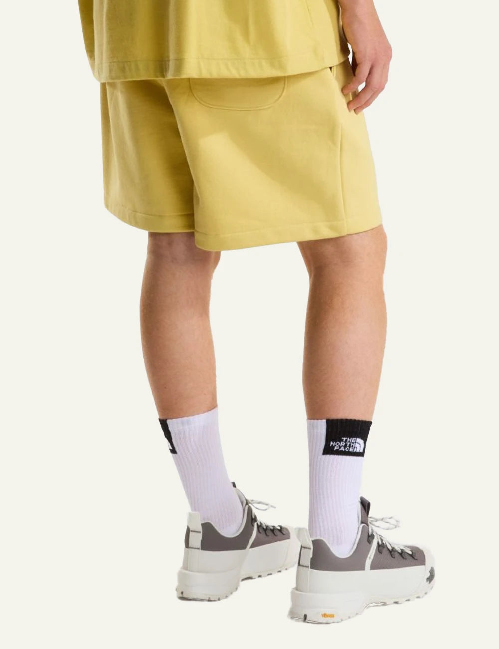 The North Face fleece shorts yellow honeyed sand front view elastic waist logo back view