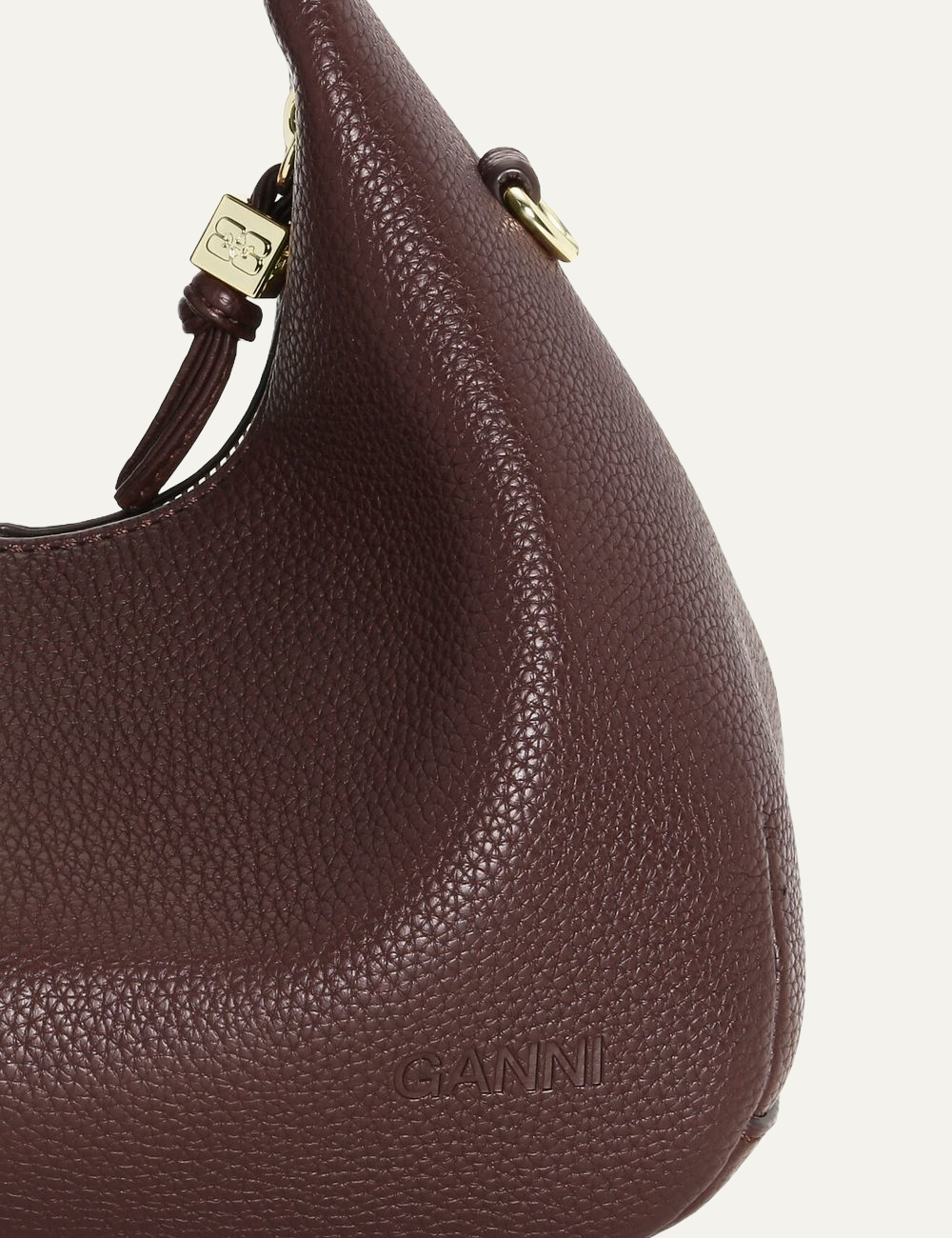 Close-up of Ganni logo on grained leather.