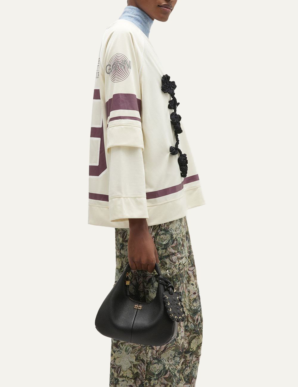 ganni hobo mini grained black bag held by model