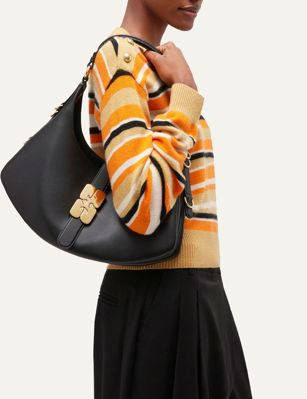 ganni kat small gold black bag with butterfly clasp held by model