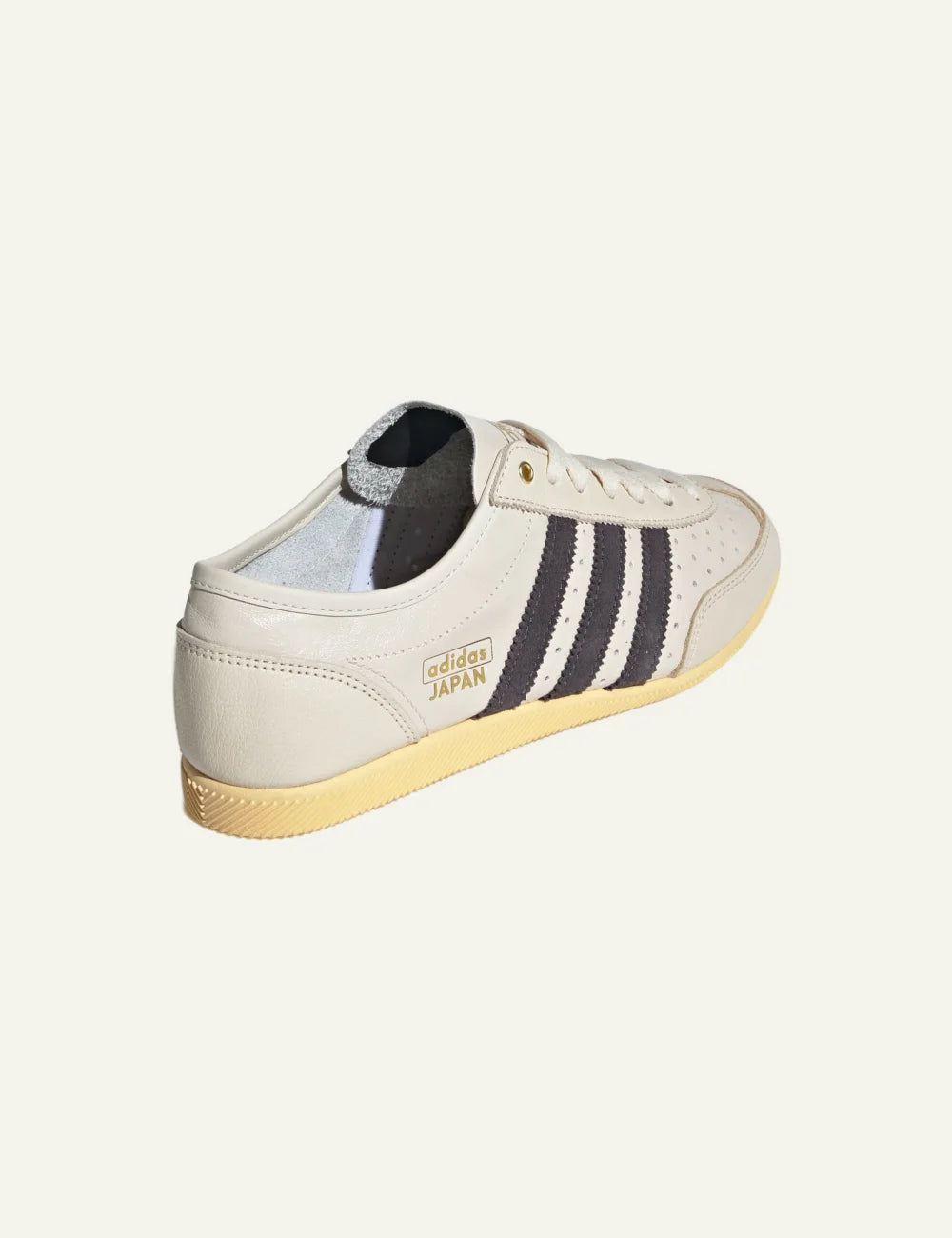 Adidas Japan sneaker σε cream white με black stripes, side view, retro low-profile design, women’s footwear.