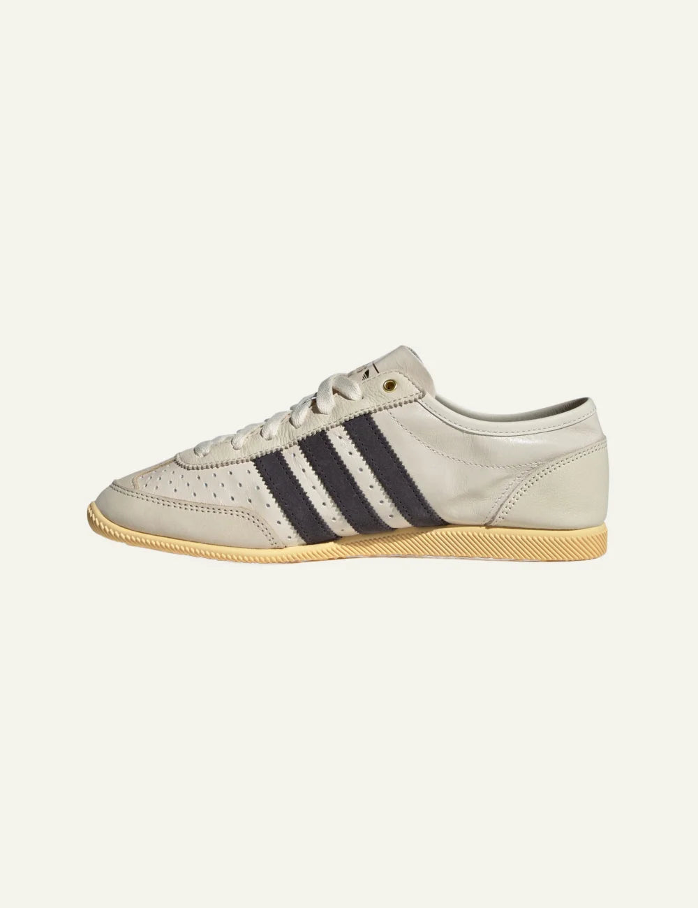 Adidas Japan retro sneaker σε light cream με contrast black stripes, minimal low-cut silhouette, lifestyle women’s shoe.