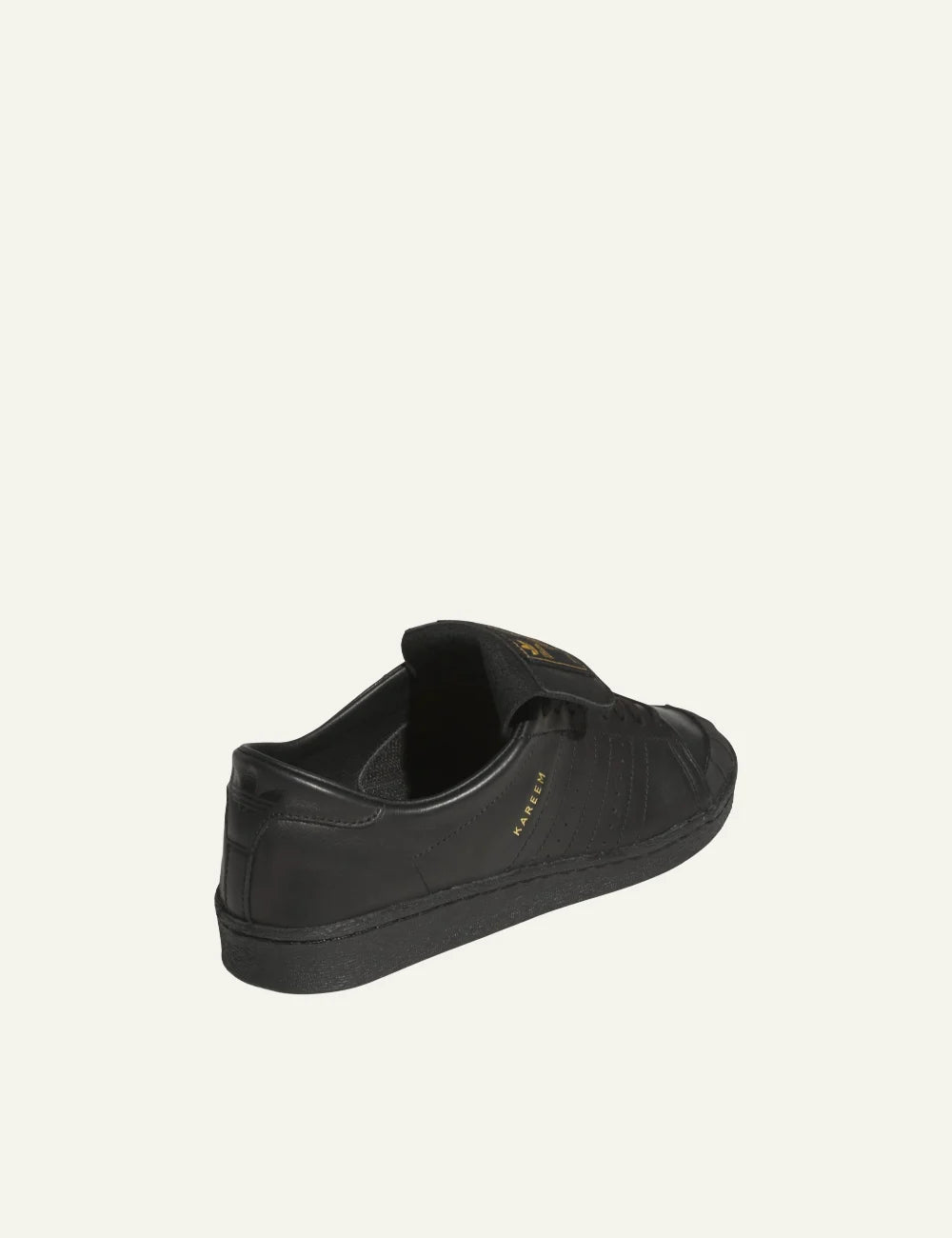 Back angle: All-black Adidas Jabbar sneaker με perforated τρεις ρίγες και soft leather heel.