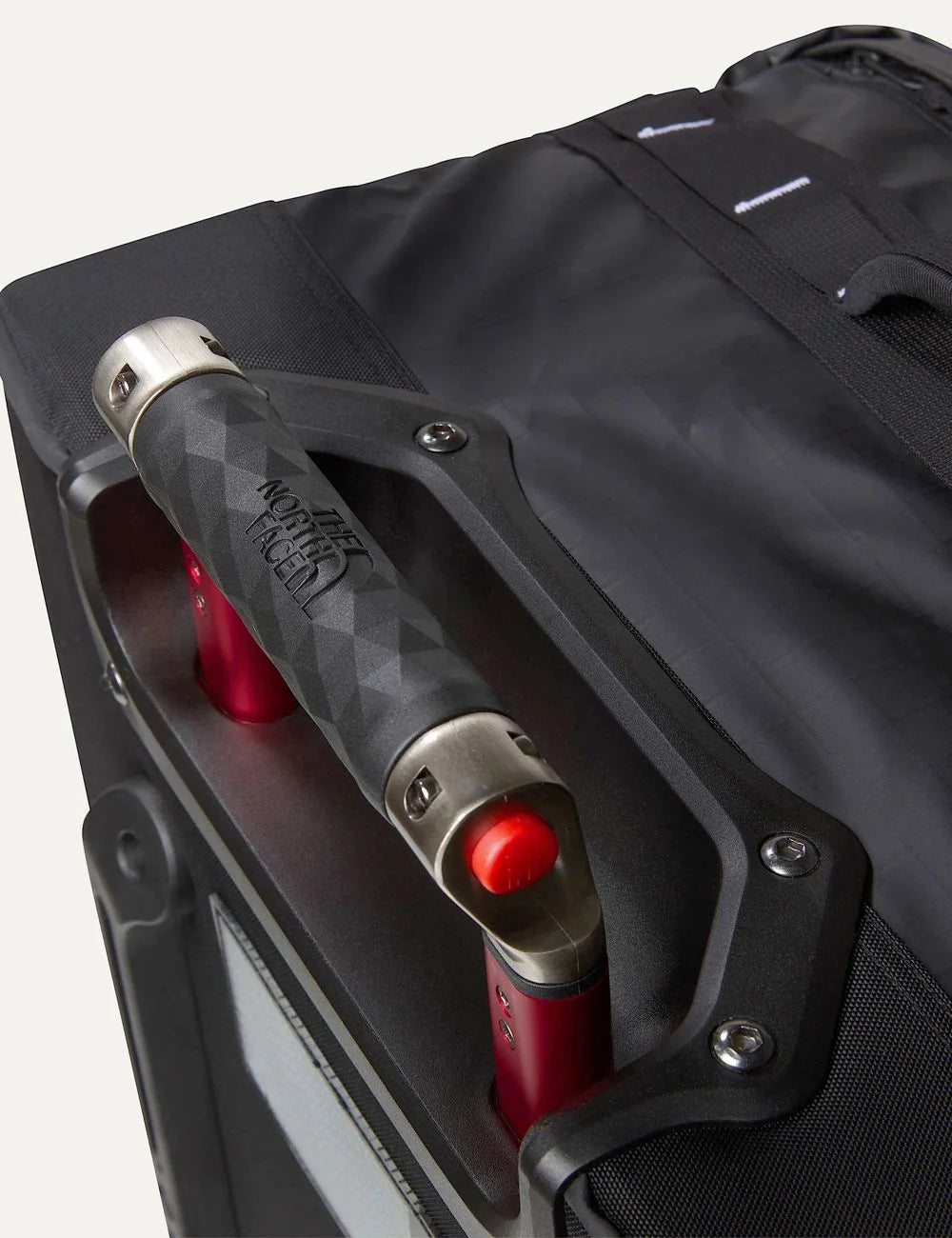 The North Face Base Camp Voyager Roller 29 black rolling travel suitcase with white logo, red telescopic handle and two wheels detail
