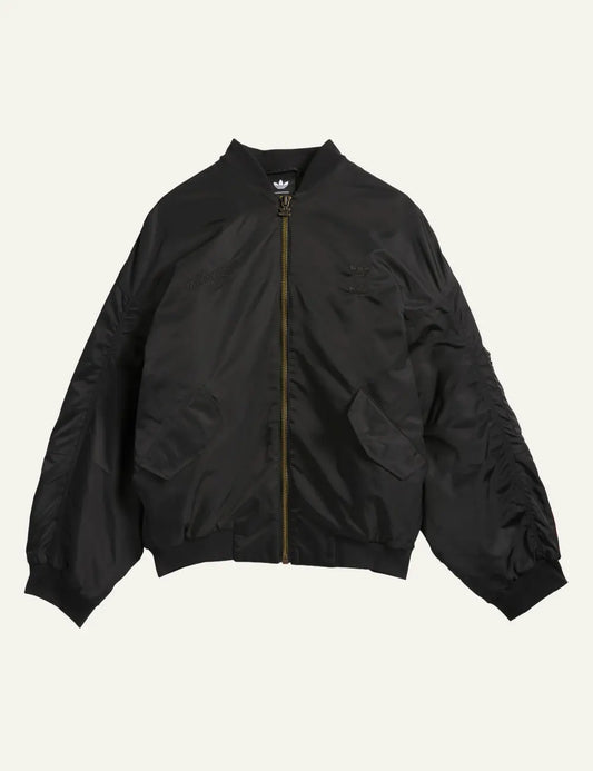 Black satin bomber jacket Adidas x Willy Chavarria σε flat lay με minimal detailing.
