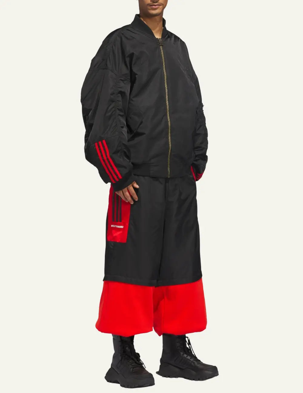 Side view of Adidas x Willy Chavarria black bomber με κόκκινες ρίγες στα μανίκια.