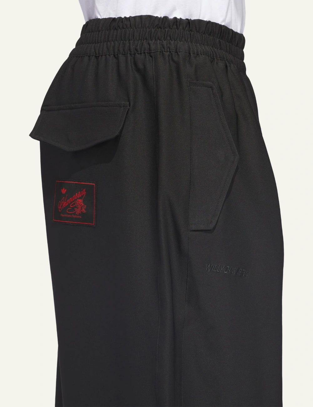 Close-up of side pocket flap and Chavarria signature patch on Adidas twill track pants.