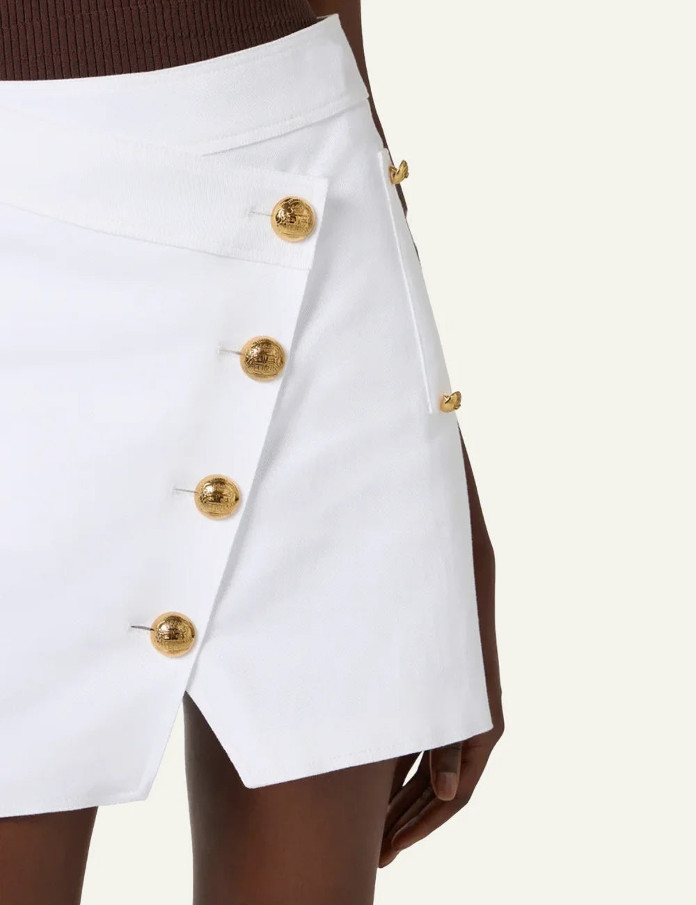 Close-up of Elisabetta Franchi white cotton gabardine miniskirt με gold military-style buttons και asymmetrical wrap design