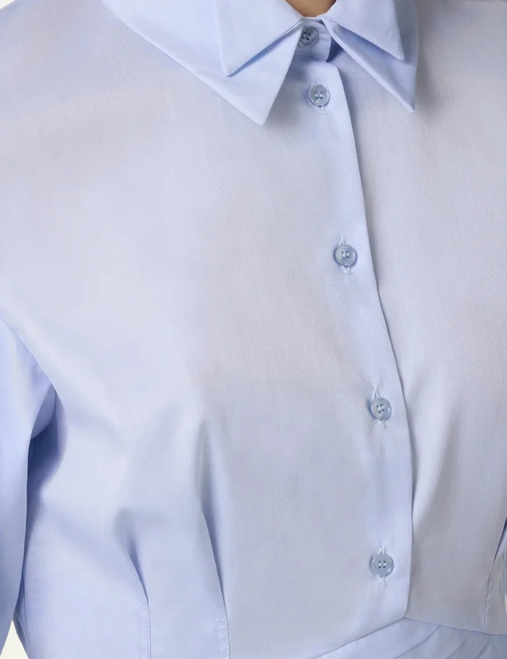 Close-up of Elisabetta Franchi white knit dress showing deep V neckline, striped detailing and signature camel belt.