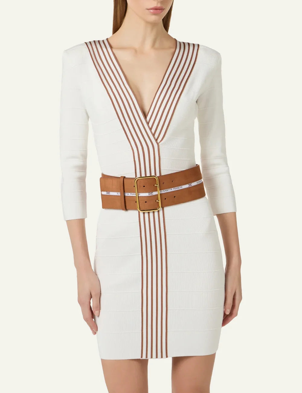 Close-up of Elisabetta Franchi white knit dress showing deep V neckline, striped detailing and signature camel belt.