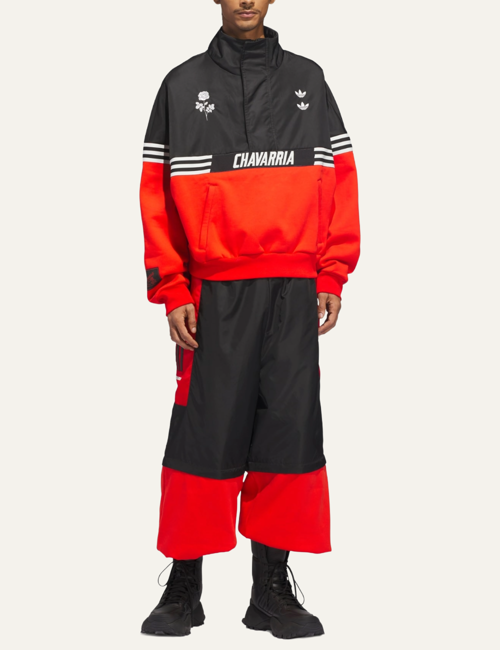 Model wearing Adidas x Willy Chavarria black/red fleece track pants in oversized streetwear look.