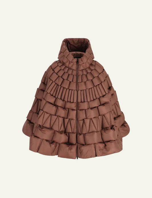 Raxxy brown 3D quilted cape puffer σε front view, με high collar και sculptural padded blocks.