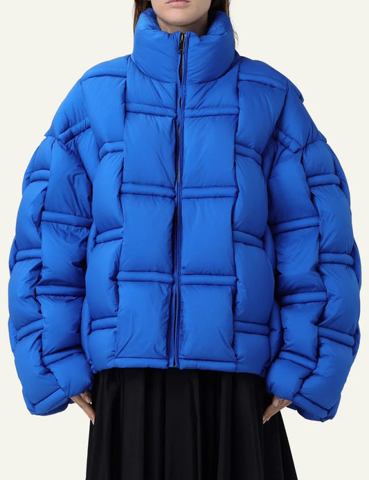Oversized puffer jacket σε electric blue, box-quilted texture, high collar, women’s outerwear fashion.
