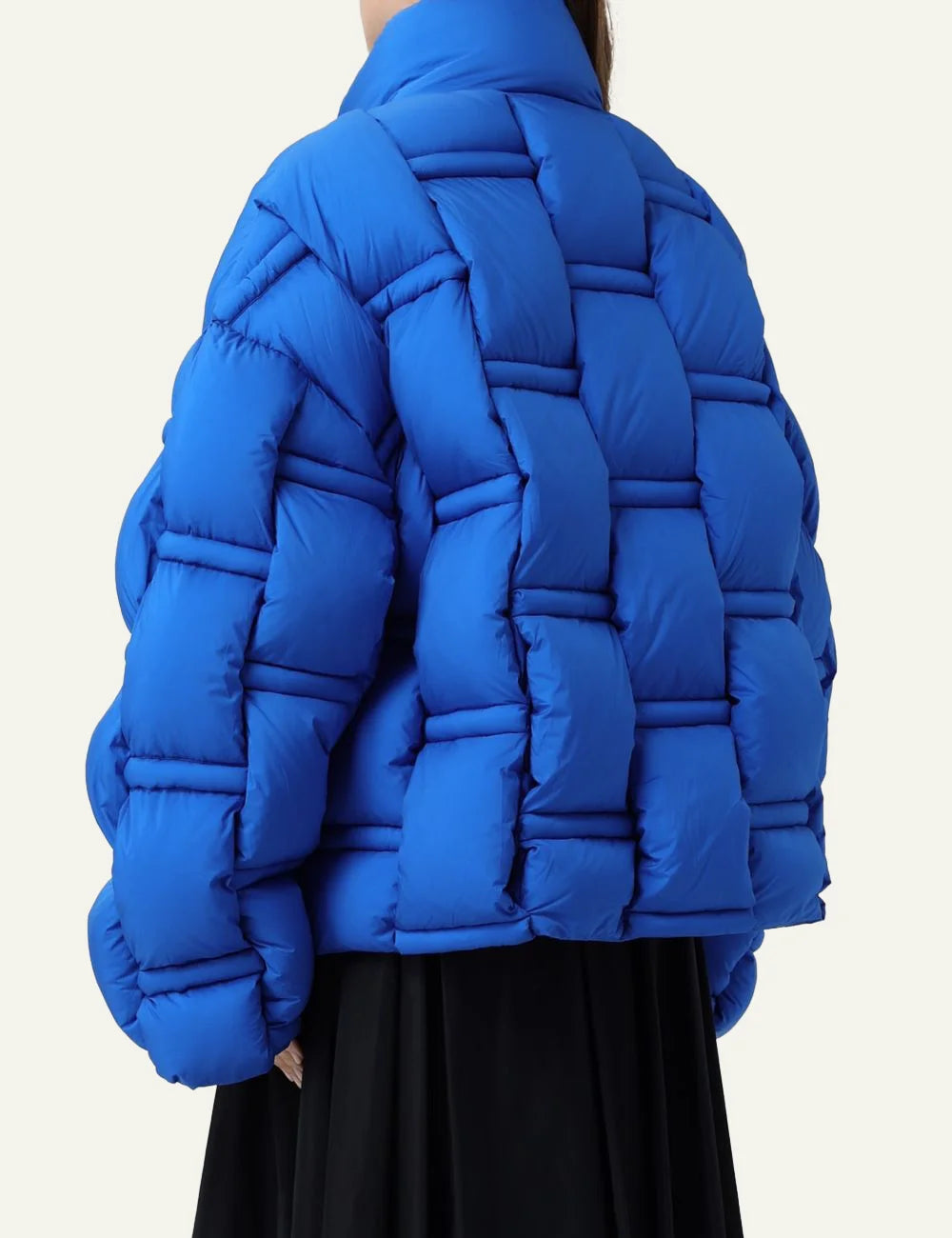 Back view of electric blue oversized puffer με geometric quilt pattern και voluminous silhouette.