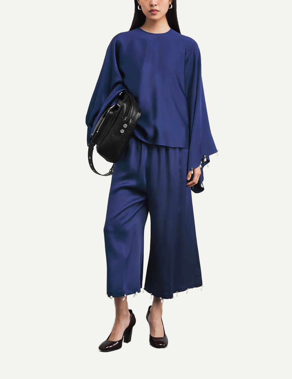 Stella McCartney μπλε σατινέ blouse full look σε μοντέλο με elegant κίνηση