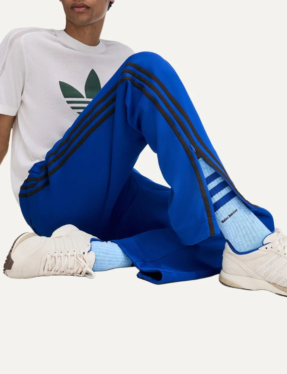 Men's Adidas Originals x Wales Bonner royal blue drop crotch track pants with dark side stripes, straight legs and embroidered Trefoil logo, on model