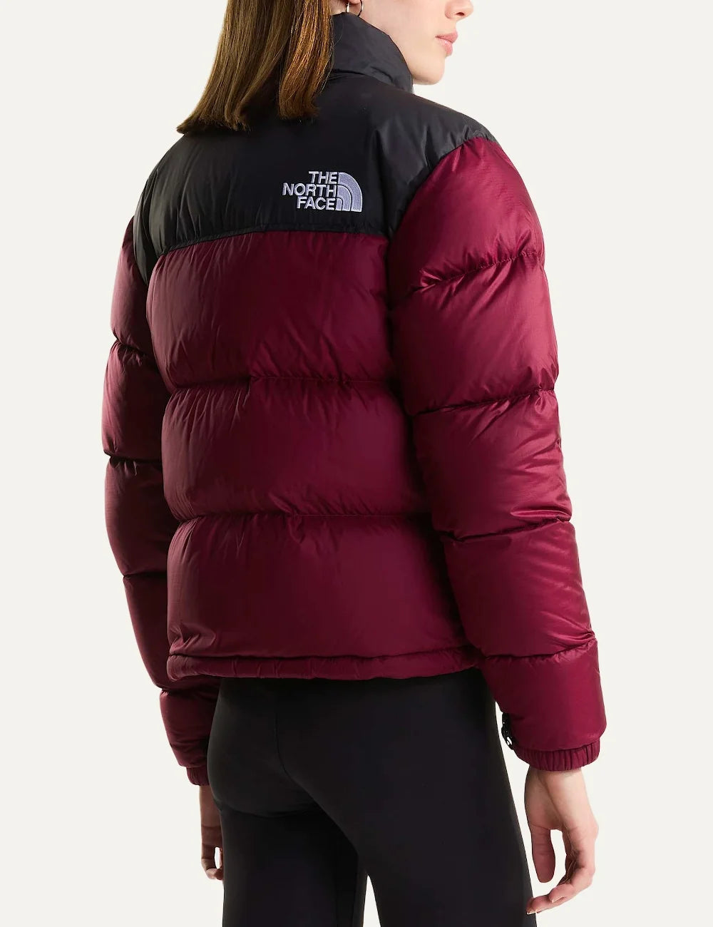 The North Face women's 1996 Retro Nuptse puffer jacket in burgundy and black with quilted down panels, high collar, front zipper and white chest logo back