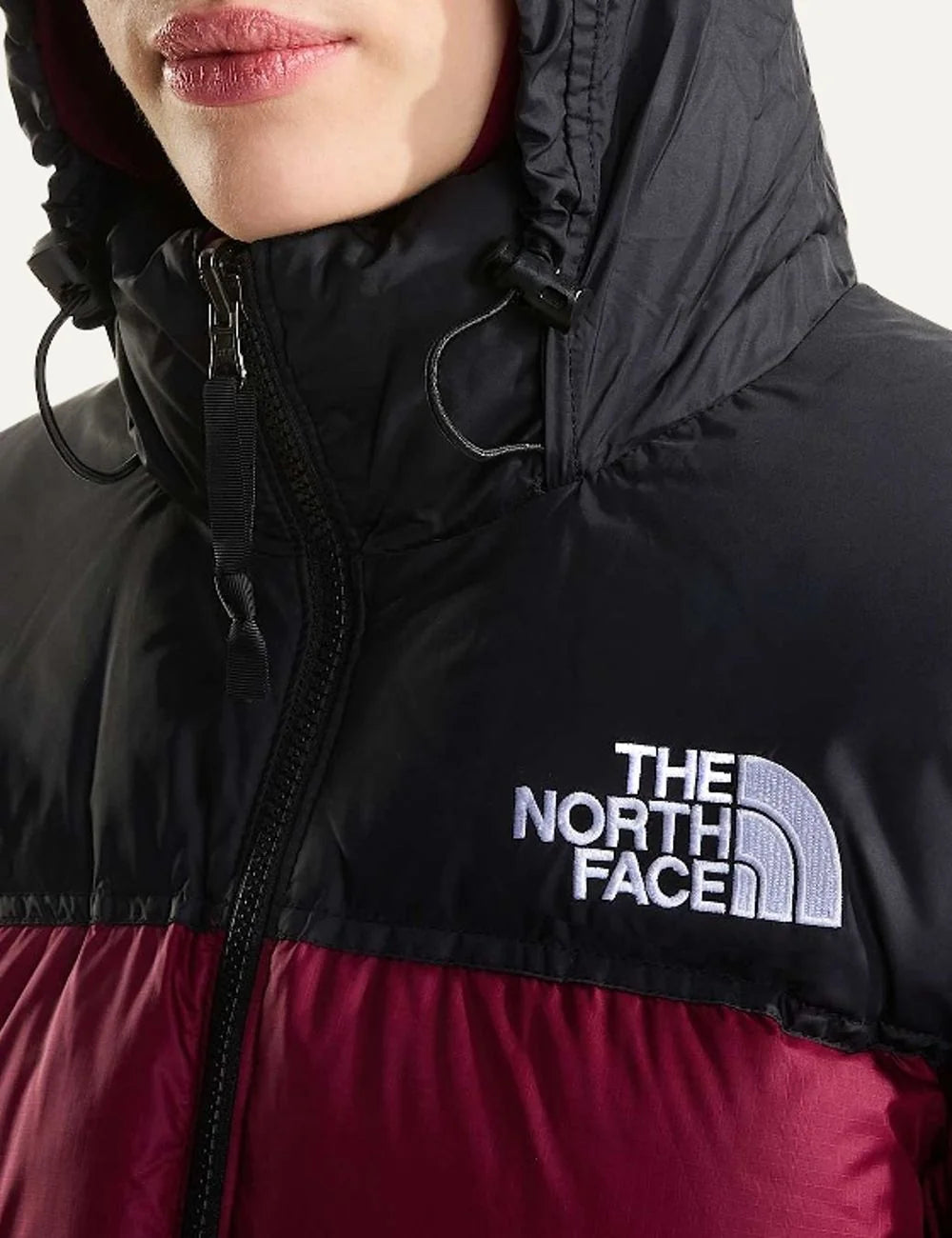 The North Face women's 1996 Retro Nuptse puffer jacket in burgundy and black with quilted down panels, high collar, front zipper and white chest logo detail