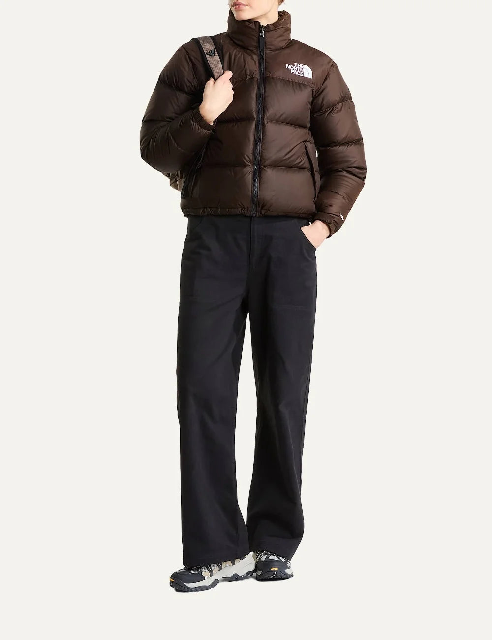 The North Face women's 1996 Retro Nuptse puffer jacket in dark chestnut brown with quilted down panels, high collar, front zip and white chest logo full body