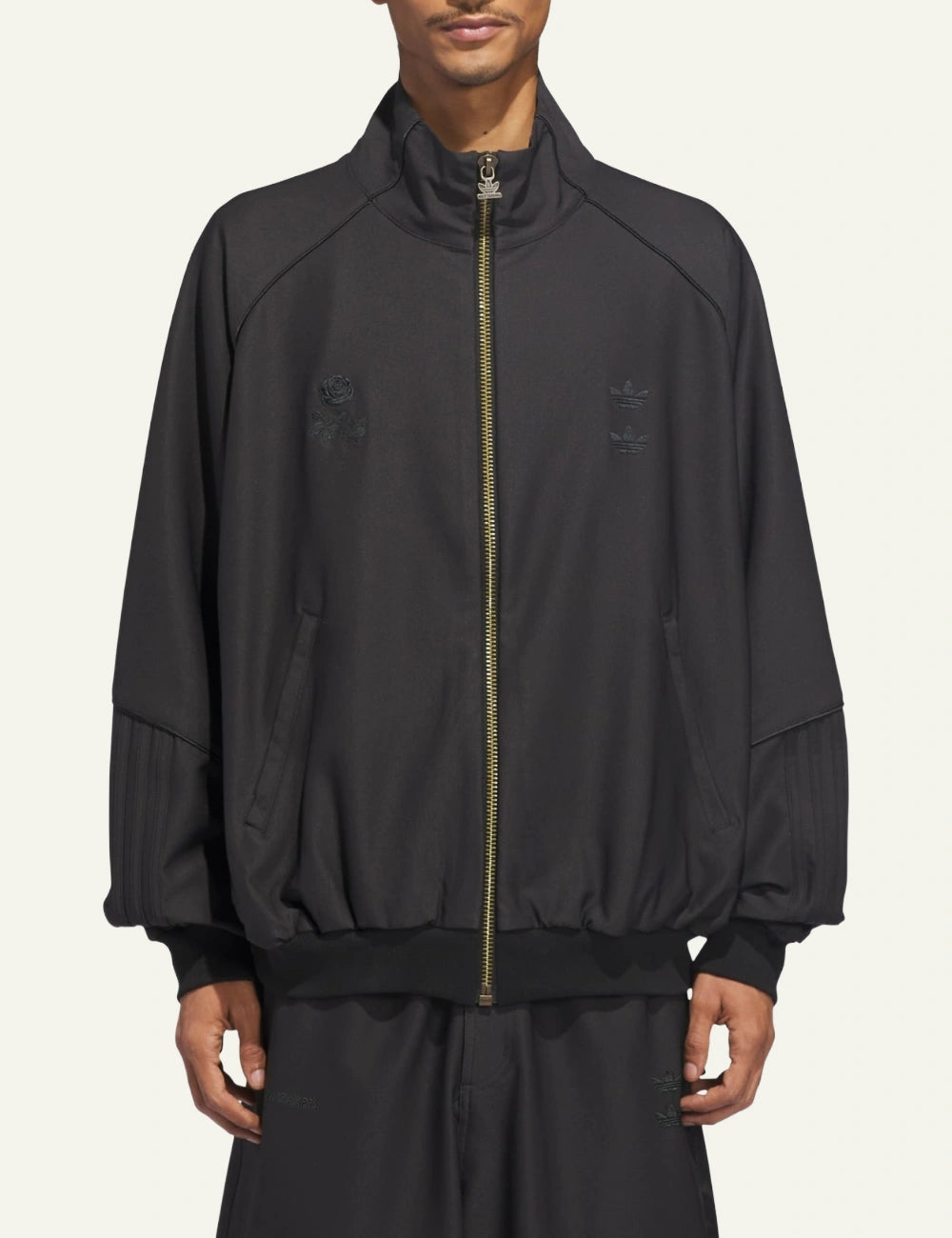 Model wearing Adidas x Willy Chavarria Twill jacket in full black with relaxed sport-inspired fit.