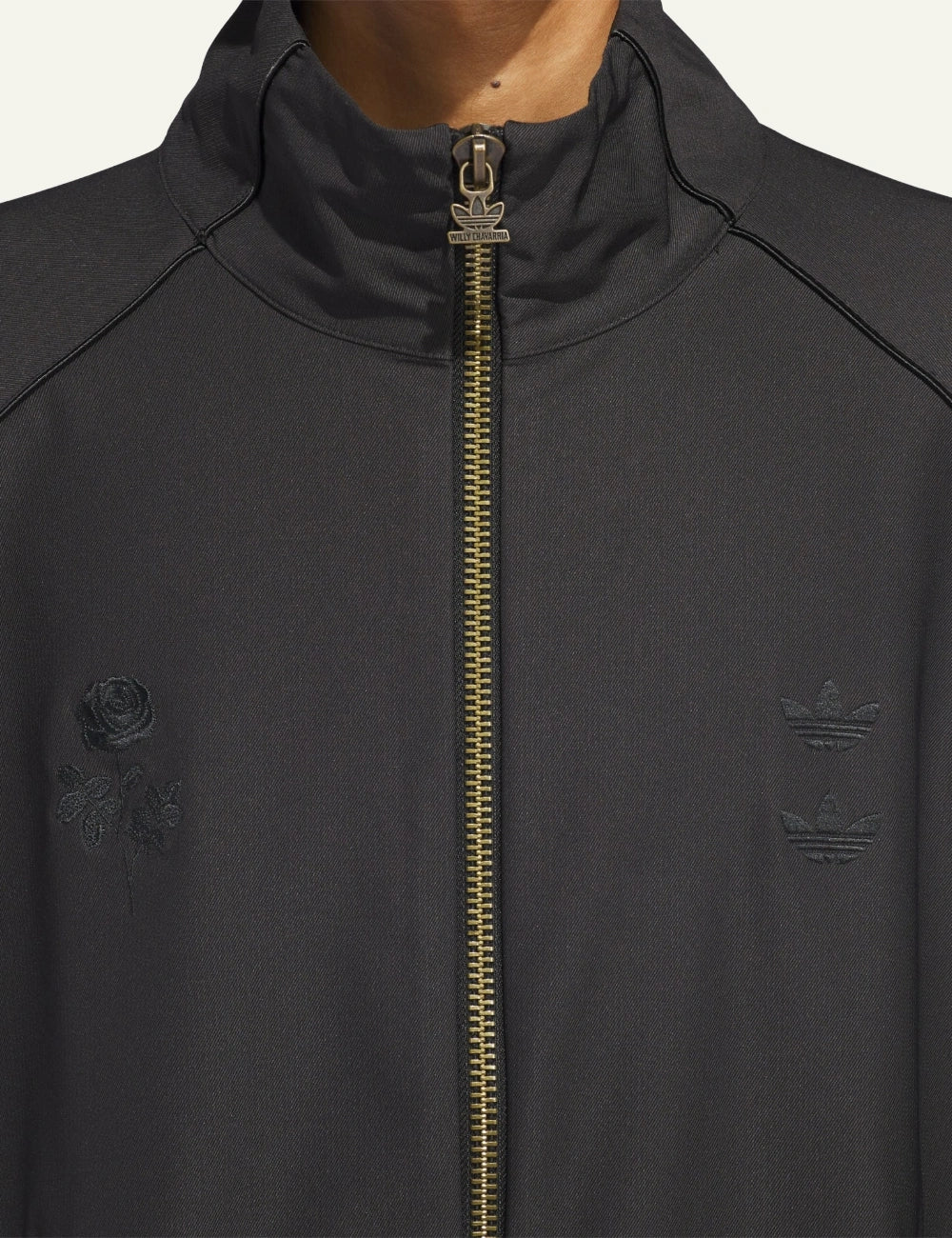 Close-up of rose embroidery and double Trefoil logos on Adidas x Willy Chavarria twill jacket.