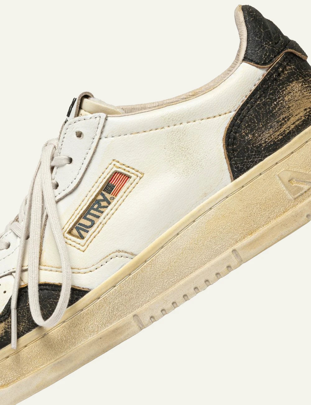 Autry men’s white and black leather sneakers with distressed vintage finish detail