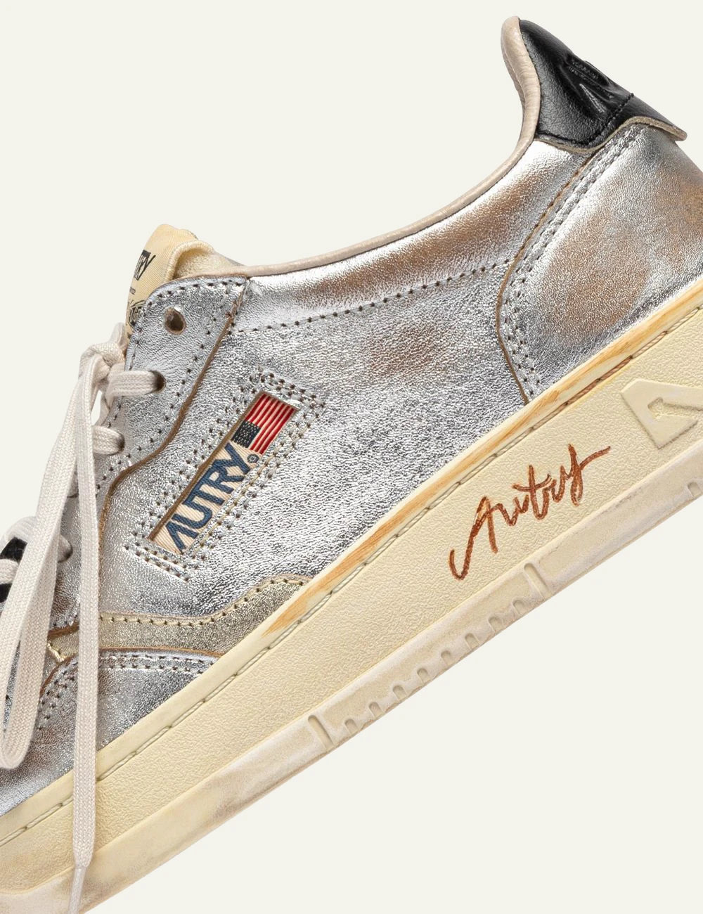 Autry women’s metallic silver leather sneakers with vintage finish detail