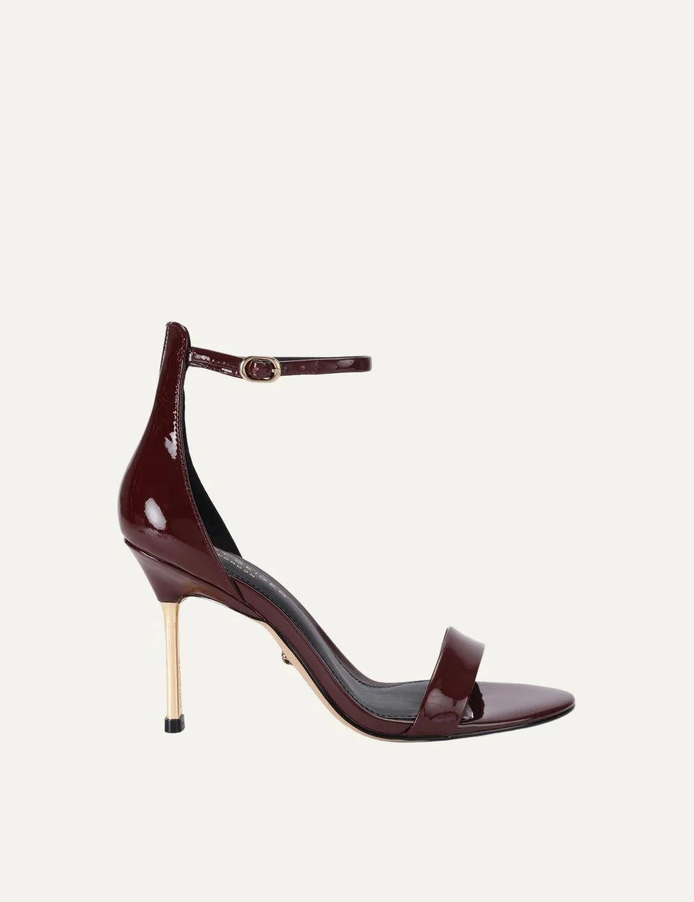 Kurt Geiger London Bank Drench wine burgundy patent leather heeled sandals with ankle strap, gold buckle and gold stiletto heel.