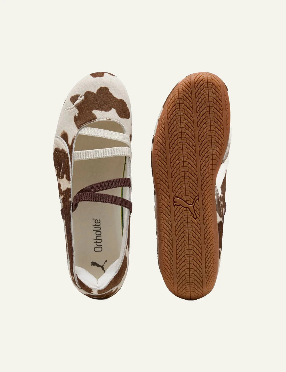 Brown and white cow print ballet flats with elastic straps sole top view
