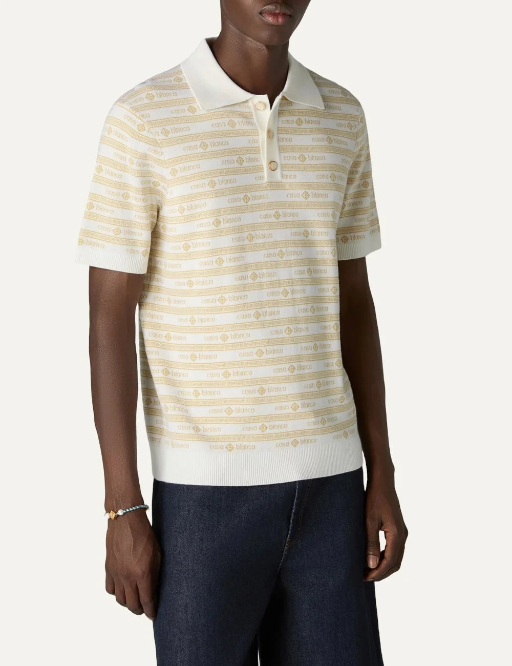 Casablanca men's beige merino wool knit polo shirt with yellow all-over logo stripes, short sleeves, ribbed collar and pearl buttons model