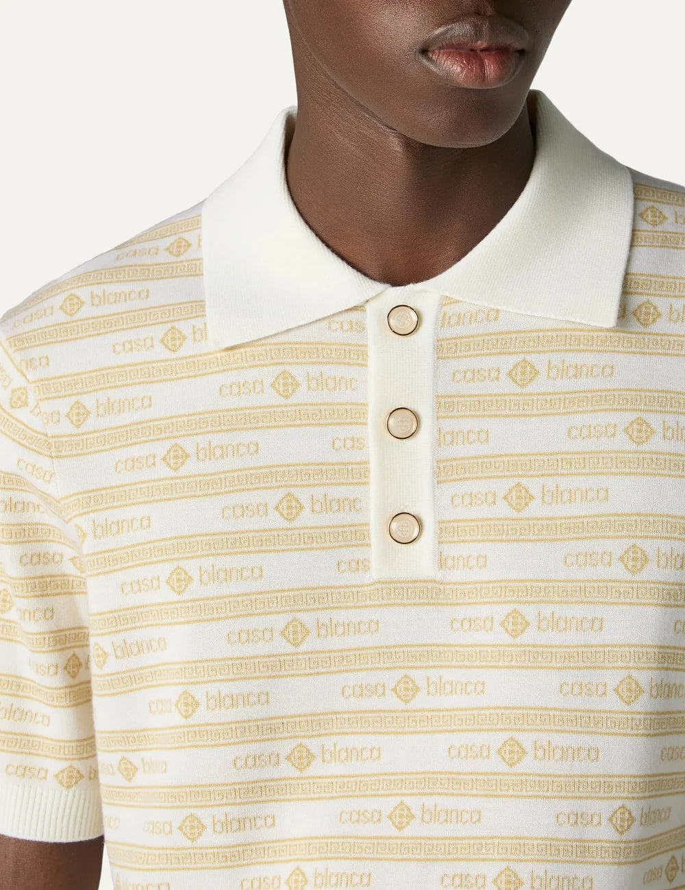 Casablanca men's beige merino wool knit polo shirt with yellow all-over logo stripes, short sleeves, ribbed collar and pearl buttons detail