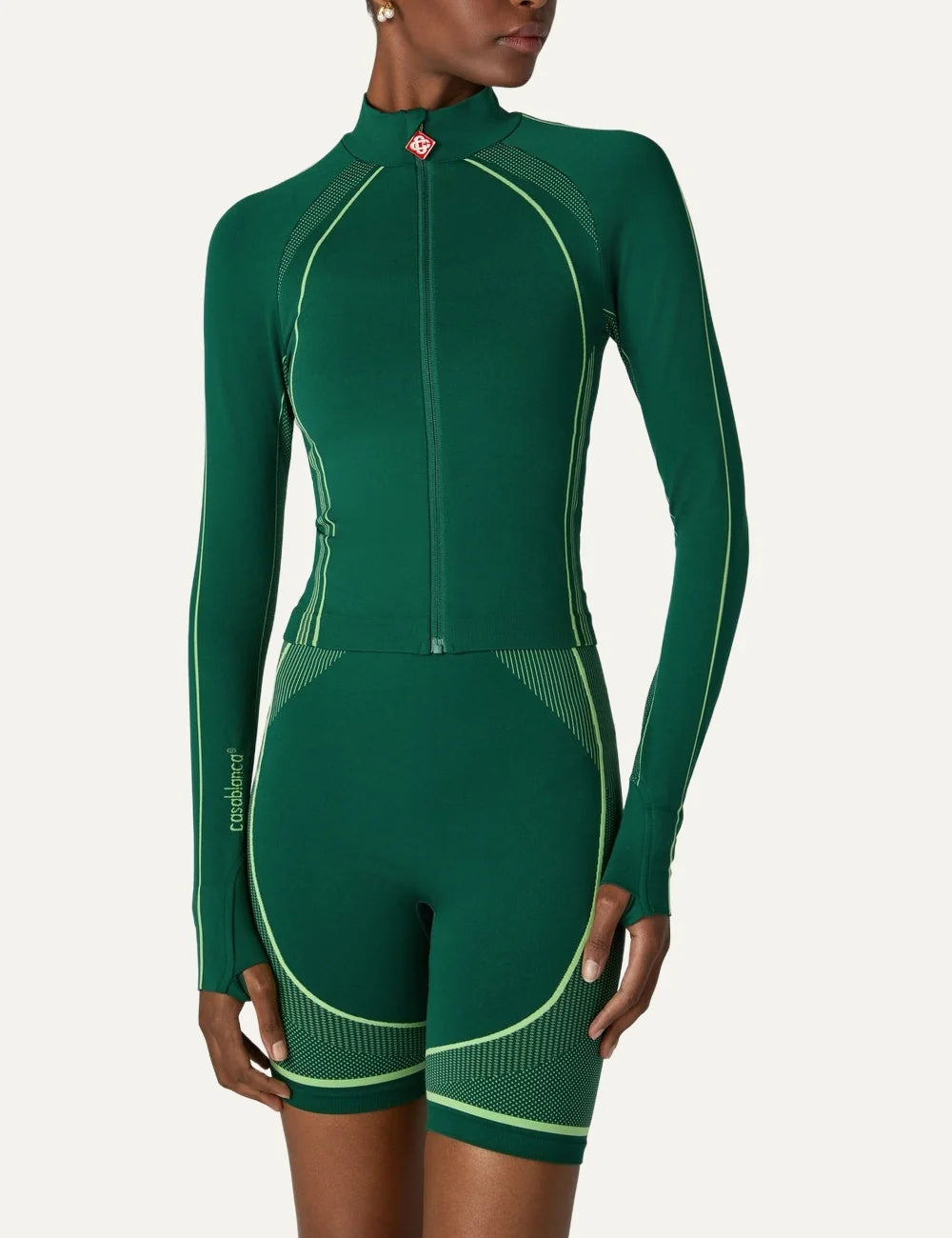 Casablanca women's green seamless zip-up jacket with high collar, light green contrast piping, fitted silhouette and thumbhole sleeves model