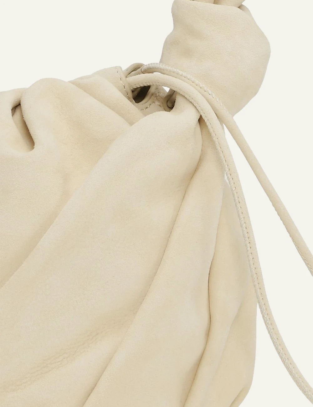 Cream leather drawstring bucket bag with shoulder strap detail view