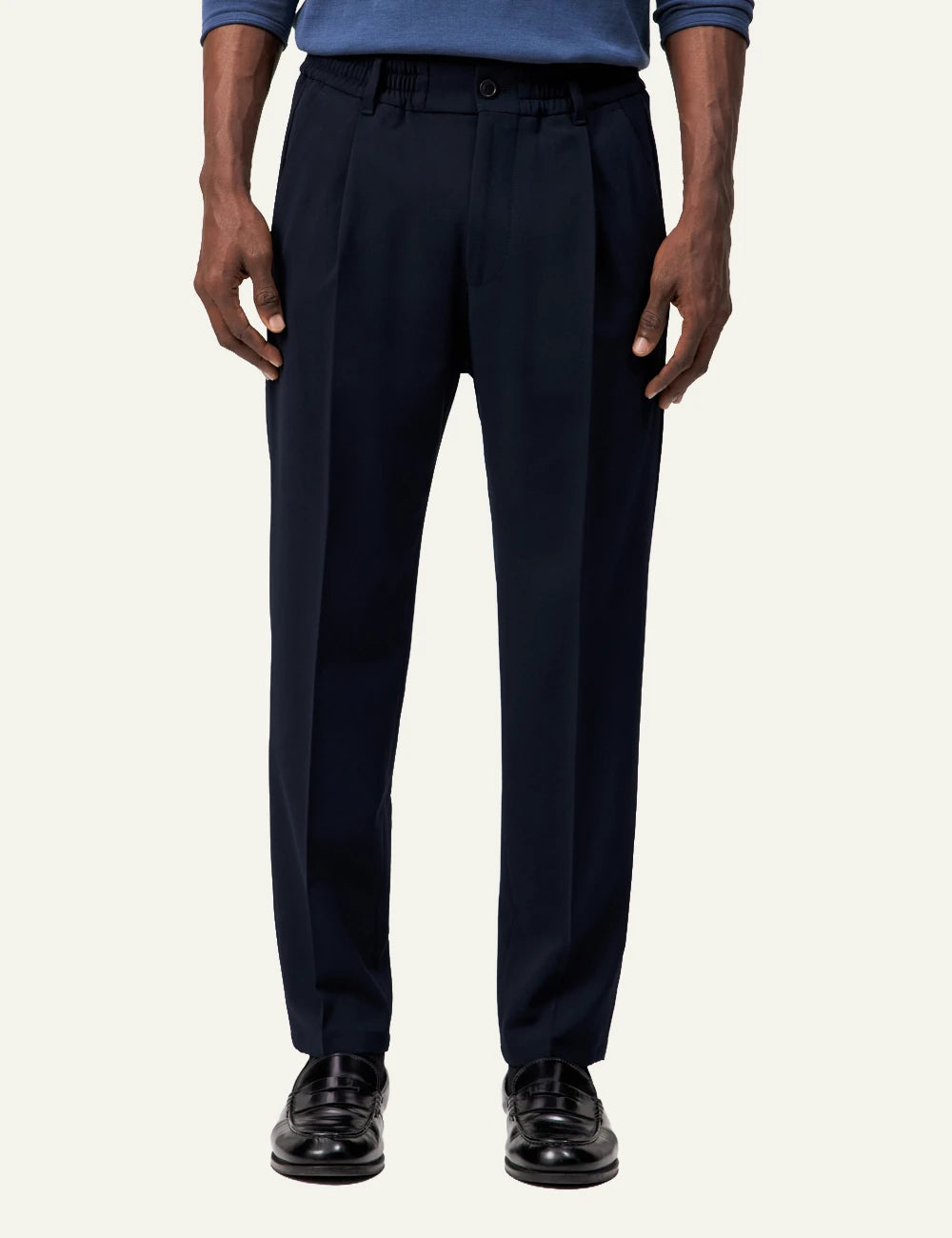 Men's DRYKORN dark navy tailored pants with tapered leg and cropped fit model