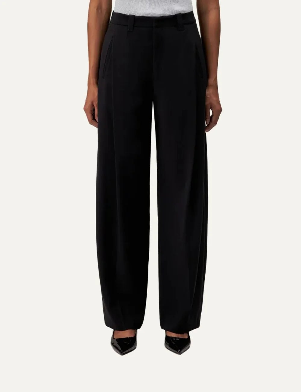 Drykorn women's black tailored trousers with front pleats, mid-rise waist, O-shaped legs and side pockets model