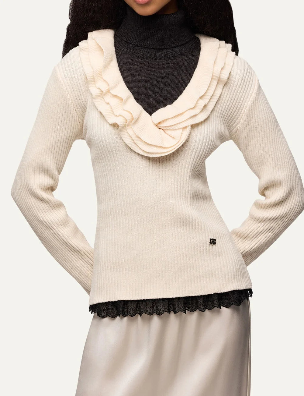 Ganni women's ecru ribbed knit top with ruffled V-neckline, long sleeves and Butterfly logo model