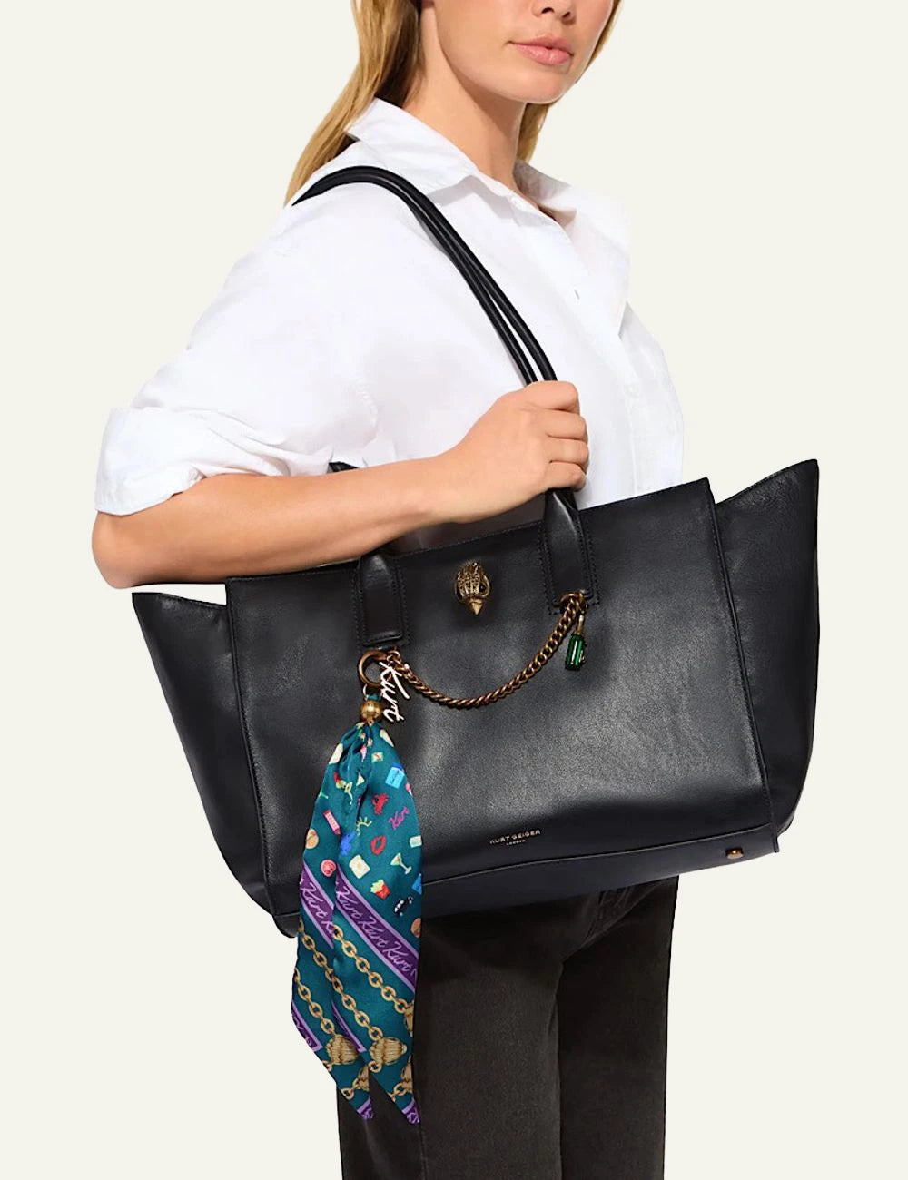 Black leather Kurt Geiger Sloane tote bag with eagle head detail, decorative chain and scarf charm model
