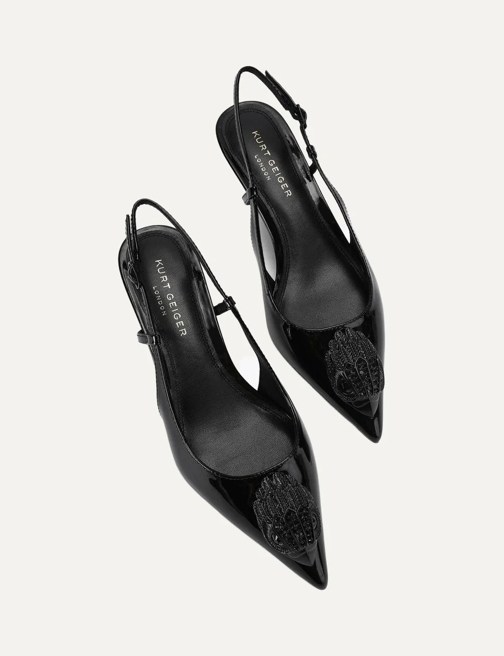 Kurt Geiger London black patent leather slingback pumps with pointed toe, crystal-embellished eagle head, adjustable strap and kitten heel top