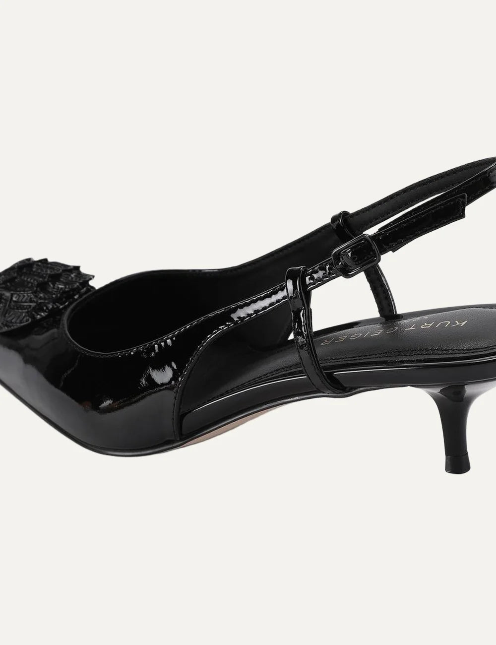 Kurt Geiger London black patent leather slingback pumps with pointed toe, crystal-embellished eagle head, adjustable strap and kitten heel back