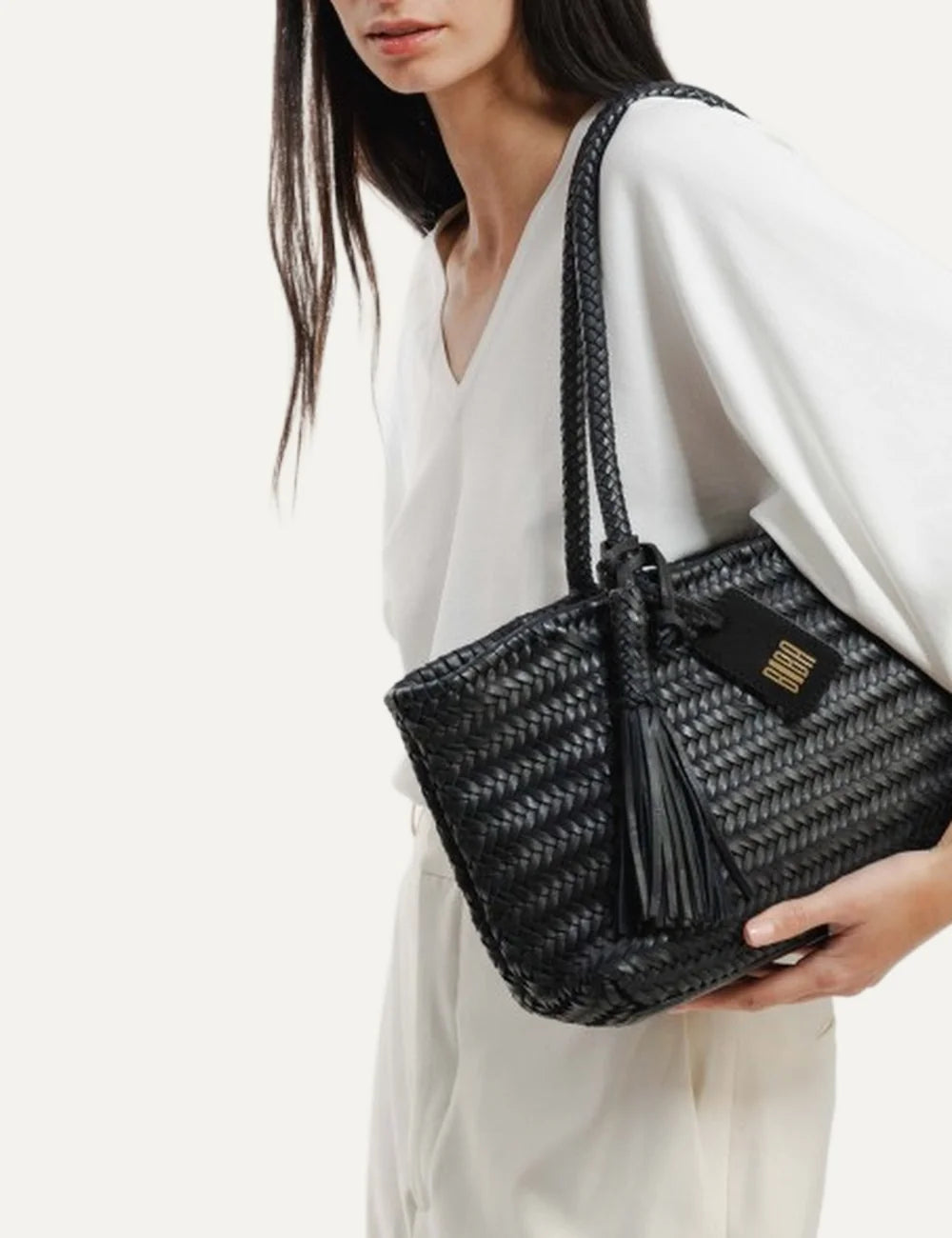 Biba Perkins black woven leather baguette shoulder bag with elongated shape, braided handles, leather tassel and logo tag model