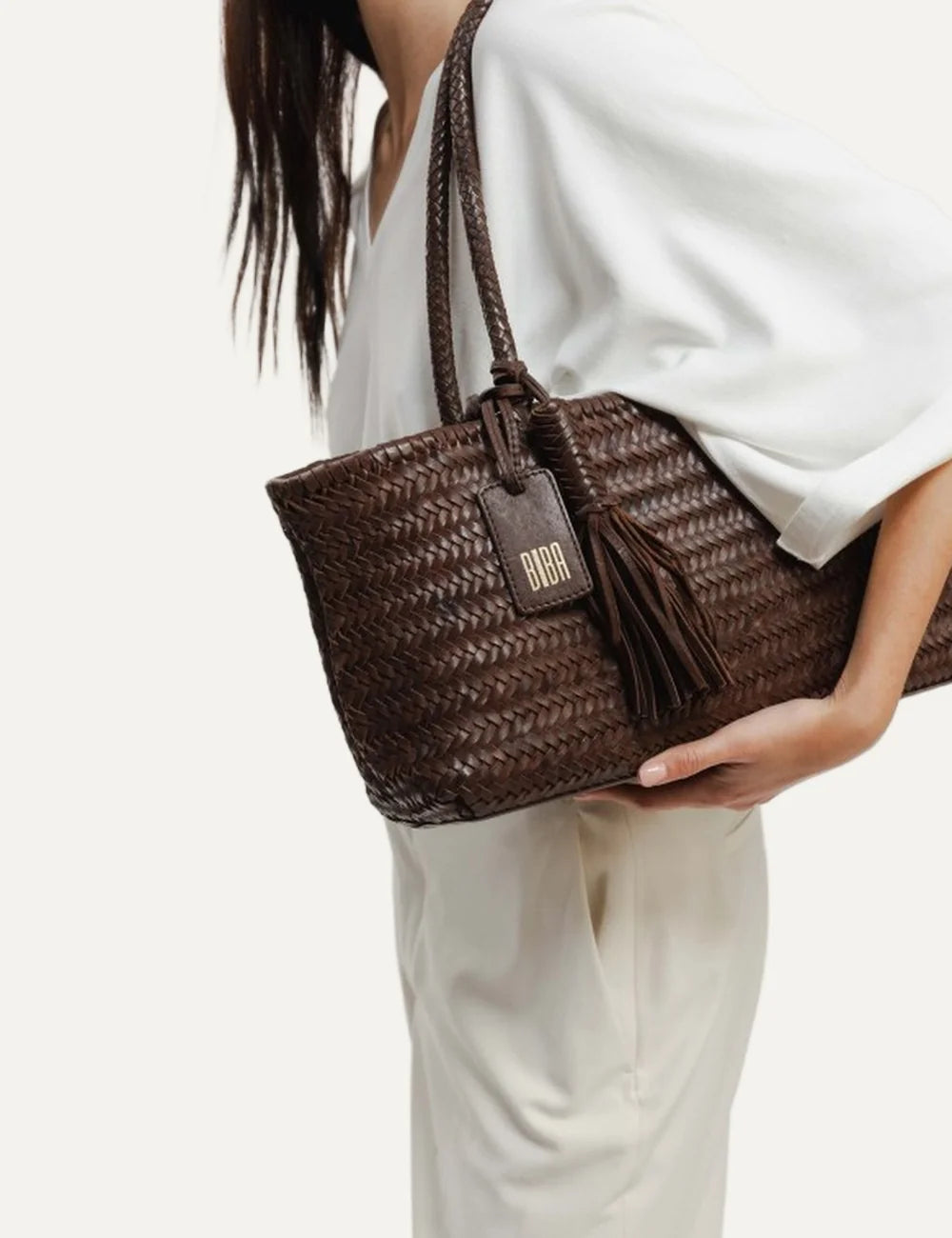 Biba women's dark brown handwoven leather baguette shoulder bag with braided handles, leather tassel and hanging Biba logo tag model
