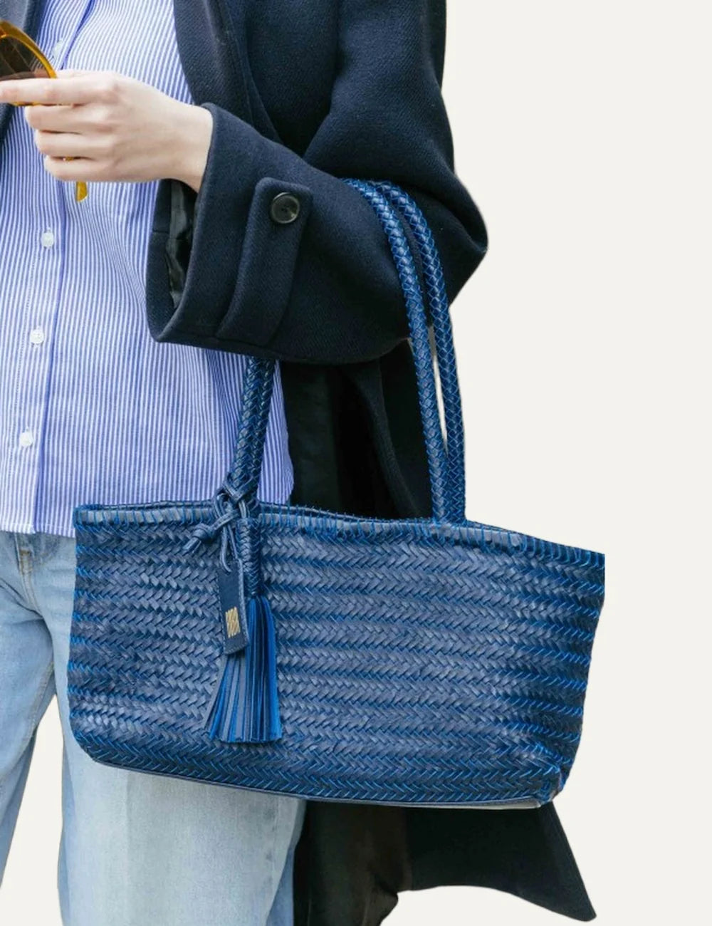 Biba Perkins blue woven leather baguette shoulder bag with elongated silhouette, braided handles, leather tassel and logo tag model
