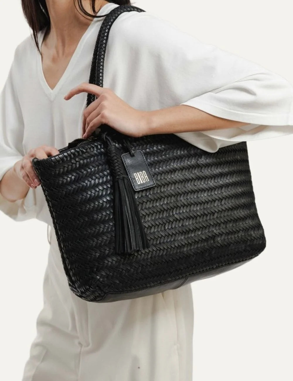 Biba Perkins black woven leather shopper bag with braided handles, herringbone texture and leather tassel side
